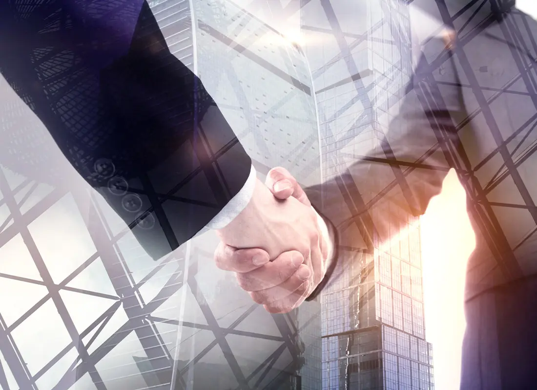 Business-Insurance-Closeup-Digitalized-Image-with-Two-Businessmen-Shaking-Hands-Against-Tall-Building-Backdrop-and-Lens-Flare