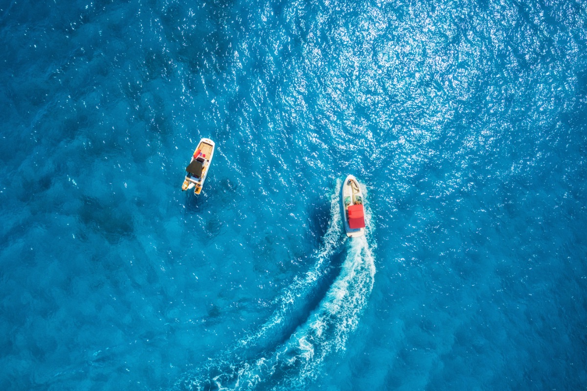 aerial-view-of-floating-motorboat-in-transparent-b-STJR6CY-2