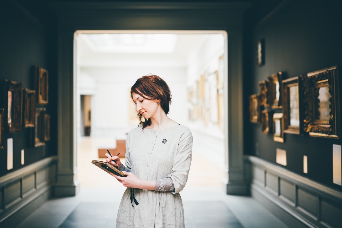 young-woman-sketching-in-museum-blurred-pictures-a-JWCUJDB-2